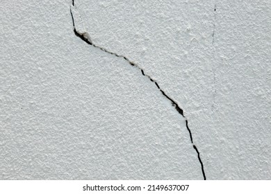 Cracks in the concrete surface can be caused by deteriorating or substandard construction materials.  The repair method should be putty to fill the cracks before painting.