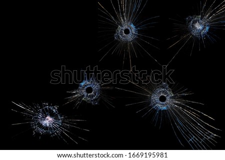 cracks on a black background on broken glass from bullet shots