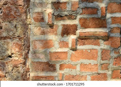 Cracks On The Red Brick Wall Of The Old Building Are Damaged. Wet With Moss And Dog Claw Marks On Shiny Leaf Walls