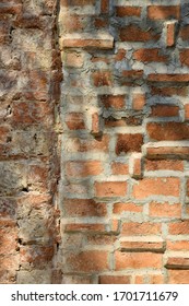 Cracks On The Red Brick Wall Of The Old Building Are Damaged. Wet With Moss And Dog Claw Marks On Shiny Leaf Walls