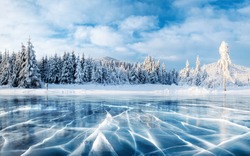 Grietas En La Superficie Del Hielo Azul. Lago Congelado En Las Montañas De Invierno. Está Nevando. Las Colinas De Los Pinos. Cárpatos Ucrania Europa.
