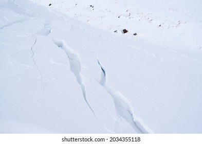 Cracks in the snow before the avalanche begins. - Shutterstock ID 2034355118