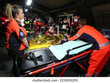 Cracow, Malopolska, Poland - 04.08.2022: Doctors Examining Intensive Care Patient Role Player In Tent Located Emergency Room Of Field Hospital During Training Exercise.