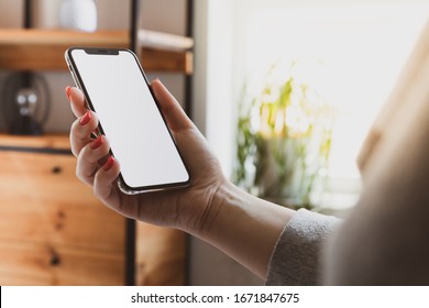 Cracow, Malopolskie / Poland - March 13 2020: Woman Hand Holding Apple IPhone 11 Pro Blank Screen On Home Interior Background