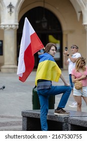 Cracow,Lesser Poland,Poland - 06.11.22 Man holding a Polish flag wrapped in the Ukrainian flag anti-war rally