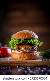 Craft Beef Burger With Cheddar, Bacon, Lettuce And Sauce On Wooden Background