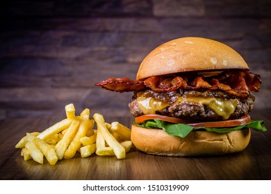 Craft beef burger with cheese, bacon, rocket leafs, caramelize onion and french fries on wood table and rustic background
 - Powered by Shutterstock