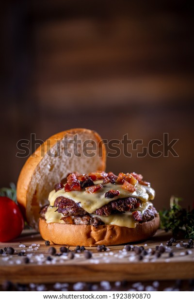 Craft beef smash burger with cheese, bacon and\
sauce on wooden\
background