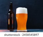 Craft beer India Pale Ale glass , dark background. An open beer bottle