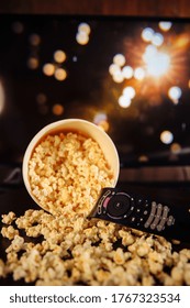 Craft Bowl Of Popcorn On The Dark Table And TV Remote Control With TV Set.