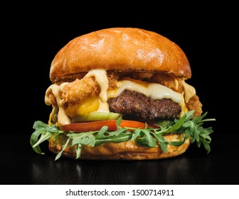 Craft burger is cooking on black background in black food gloves. Consist: sauce, arugula, tomato, red onion rings fries, cucumber, cheese, air bun and marble meat beef. Not made ideal. Looks real - Powered by Shutterstock