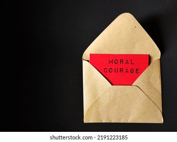 Craft Envelope On Black Background With Text On Red Card MORAL COURAGE, Means Courage To Take Action For Moral Reasons Or Act Upon Ethical Values To Help Others During Difficult Ethical Dilemmas