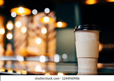 Craft Glass Of Coffee Is On The Display Case Against The Background Of Glowing Bokeh.