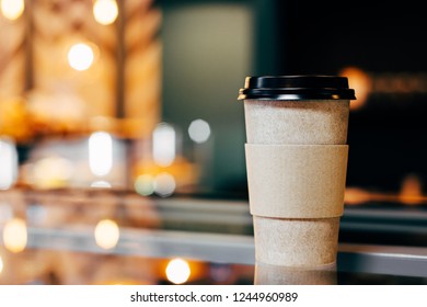 Craft Glass Of Coffee Is On The Display Case Against The Background Of Glowing Bokeh.