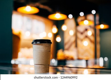 Craft Glass Of Coffee Is On The Display Case Against The Background Of Glowing Bokeh.