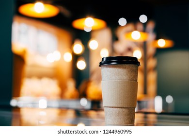 Craft Glass Of Coffee Is On The Display Case Against The Background Of Glowing Bokeh.