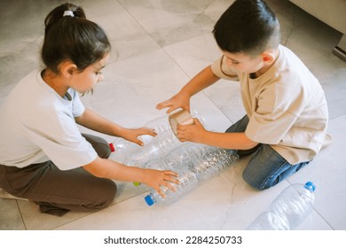 Craft Idea for Kids: Recycled Toy Tower From Plastic Bottles, Teaching Environmental Responsibility through Creative Reuse, Top View Shot with Selective Focus. - Powered by Shutterstock