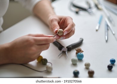 Craft jewelery making with professional tools. Jewelry designer working in studio with tools making earrings. Close-up of female hands working with jewelry tools - Powered by Shutterstock