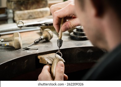 Craft jewelery making.  Repairing ring by inlaid tight gem.