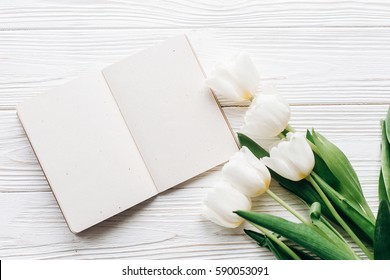 Craft Notebook, Pen And Stylish Tulips On White Wooden Rustic Background. Flat Lay With Flowers And Paper Note With Space For Text. Woman Working. Idea Book. Fresh Start  Happy Mothers Womens Day