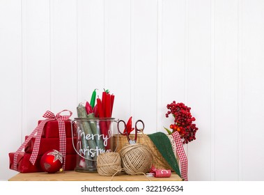 Craft Supplies For Red White Christmas Gifts On A White Wall For A Creative Background.