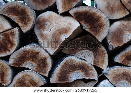 Crafted with natural elements, this image showcases a beautifully arranged stack of split wood logs. The unique heart-shaped log in the center adds a touch of rustic charm and emotional depth. The var
