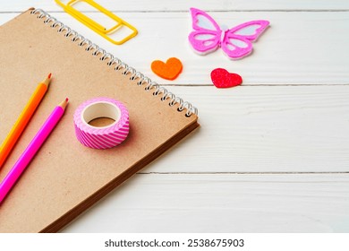 Crafting inspiration with colored pencils, decorative tape, and playful shapes on a rustic wooden surface - Powered by Shutterstock