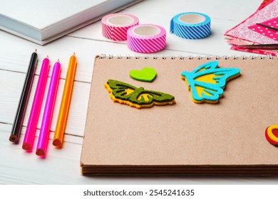 Crafting inspiration with colored pencils, decorative tape, and playful shapes on a rustic wooden surface - Powered by Shutterstock