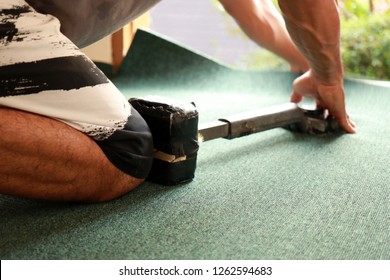 craftman use knee kickers to push wall to wall carpet in the installation process