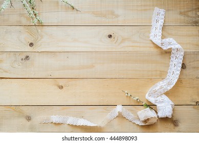 crafts concept, lace ribbon and flowering branch on wooden table - Powered by Shutterstock