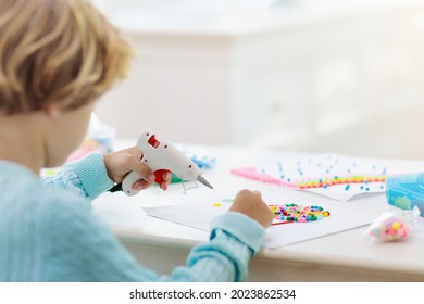 Crafts For Kids. Child With Hot Glue Gun. Creative Little Boy Sticking Buttons And Beads In Rainbow Design. Art And Creativity Class In School Or Kindergarten. Preschool Kid With Fun Diy Project.