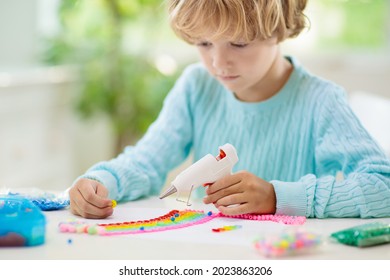 Crafts For Kids. Child With Hot Glue Gun. Creative Little Boy Sticking Buttons And Beads In Rainbow Design. Art And Creativity Class In School Or Kindergarten. Preschool Kid With Fun Diy Project.