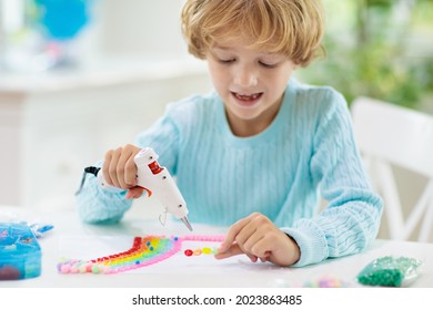 Crafts For Kids. Child With Hot Glue Gun. Creative Little Boy Sticking Buttons And Beads In Rainbow Design. Art And Creativity Class In School Or Kindergarten. Preschool Kid With Fun Diy Project.