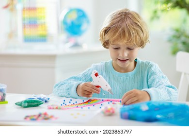 Crafts For Kids. Child With Hot Glue Gun. Creative Little Boy Sticking Buttons And Beads In Rainbow Design. Art And Creativity Class In School Or Kindergarten. Preschool Kid With Fun Diy Project.