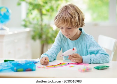 Crafts For Kids. Child With Hot Glue Gun. Creative Little Boy Sticking Buttons And Beads In Rainbow Design. Art And Creativity Class In School Or Kindergarten. Preschool Kid With Fun Diy Project.