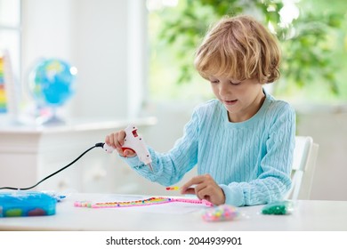 Crafts For Kids. Child With Hot Glue Gun. Creative Little Boy Sticking Buttons And Beads In Rainbow Design. Art And Creativity Class In School Or Kindergarten. Preschool Kid With Fun Diy Project.