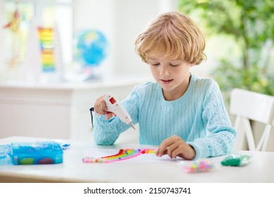 Crafts For Kids. Child With Hot Glue Gun. Creative Little Boy Sticking Buttons And Beads In Rainbow Design. Art And Creativity Class In School Or Kindergarten. Preschool Kid With Fun Diy Project.