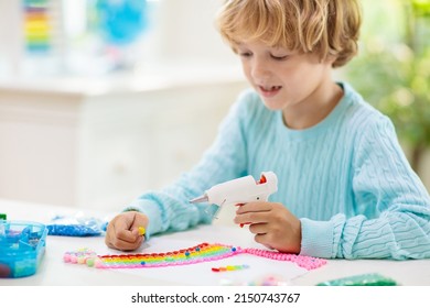 Crafts For Kids. Child With Hot Glue Gun. Creative Little Boy Sticking Buttons And Beads In Rainbow Design. Art And Creativity Class In School Or Kindergarten. Preschool Kid With Fun Diy Project.