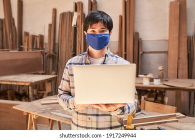 Craftsman Apprentice With Face Mask Because Of Covid-19 With Laptop Computer