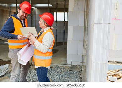 Craftsman and architect on the shell construction site with tablet computer during construction planning