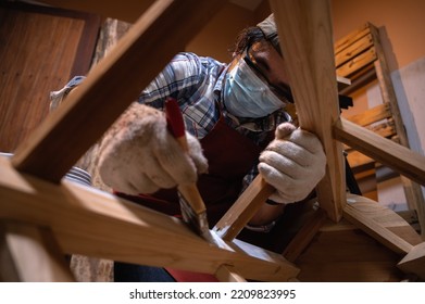 Craftsman, Carpenter Using A Paintbrush Painting To Wooden Bar Chair Handmade At Woodworking Workshop Or Carpentry Workplace.