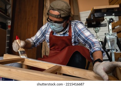 Craftsman, Carpenter Using A Paintbrush Painting To Wooden Bar Chair Handmade At Woodworking Workshop Or Carpentry Workplace.