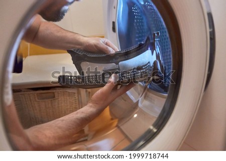 Craftsman cleans the lint filter from the tumble dryer in the bathroom or laundry room