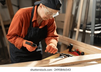 Craftsman and DIY handmade. Female carpenter uses chisel to make wood furniture while working in workshop. Copy space - Powered by Shutterstock