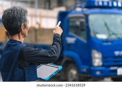 A craftsman holding a tablet to inspect the construction site. - Powered by Shutterstock