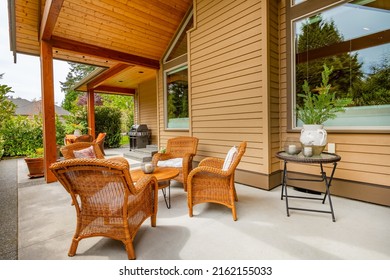 Craftsman home cedar siding solid wood pillars patio veranda deck grassy green yard blue sky and landscaping
