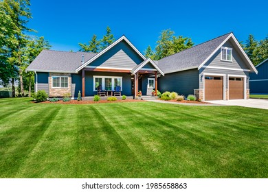 Craftsman home with double garage lush green lawn and blue sky