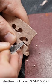 A craftsman makes a string stand with a sharp chisel