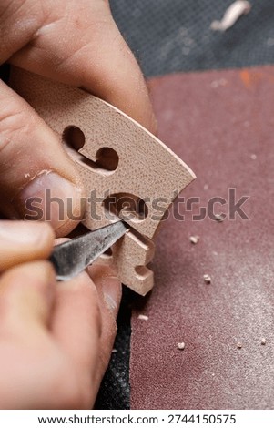 A craftsman makes a string stand with a sharp chisel