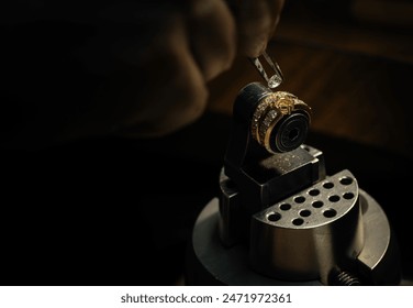 craftsman making diamond ring. hand made jewelery. Put diamond gem ring. diamond ring production. hand made in craftsman workshop close up. black background.